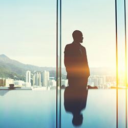 silhouette of person standing at window looking out